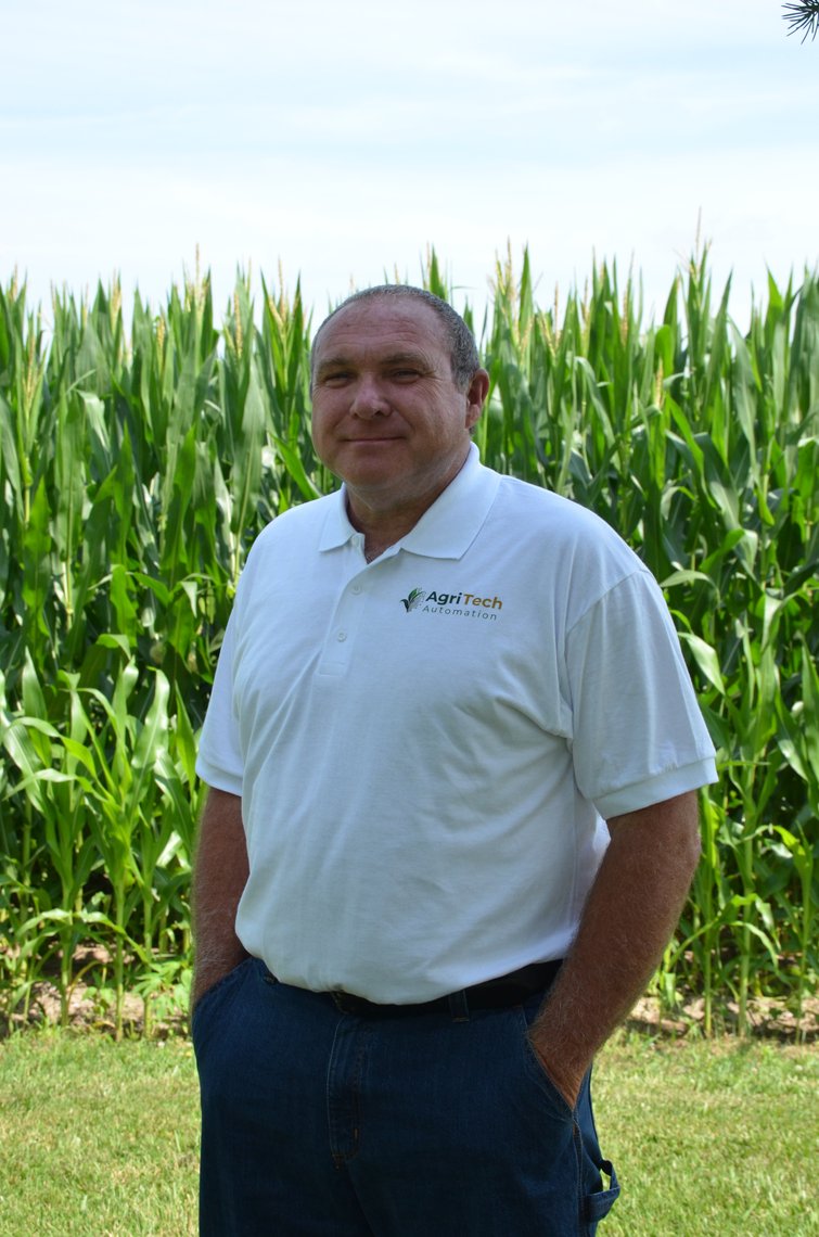 Eric Lewsader, co-founder of AgriTech Automation, standing in front of a corn field